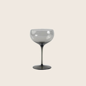 Elegant stemmed glass with smoky tint, minimalist background, polished sheen.