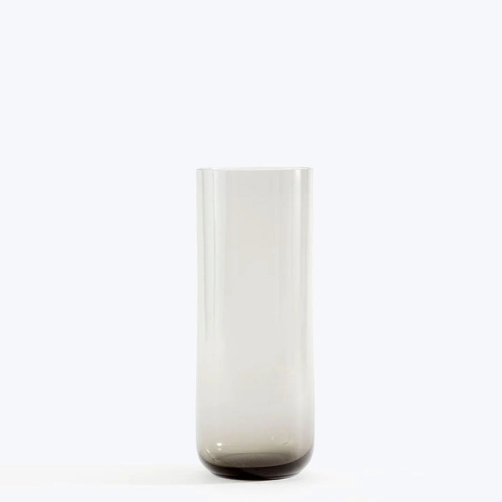 Minimalist glass vase with gradient color against light background.