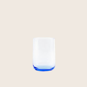 Empty blue tinted drinking glass on white background with shadow.