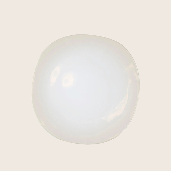 Minimalist white plate with glossy finish on neutral background