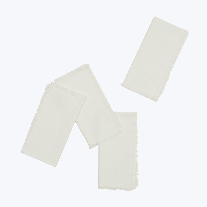 Three cream fabric pieces layered with fringed edges, white background.