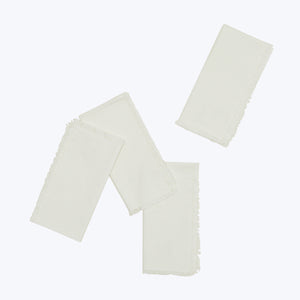 Three cream fabric pieces layered with fringed edges, white background.