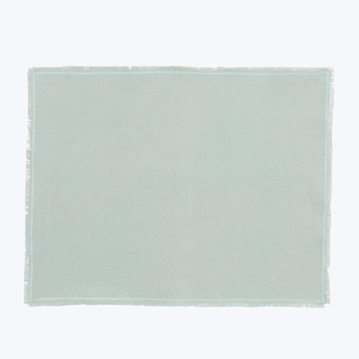 Light green or gray fabric with frayed edge, overhead view.
