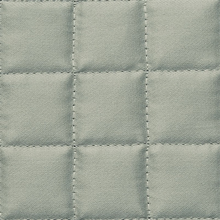 Textured quilted fabric with raised squares in pale color.