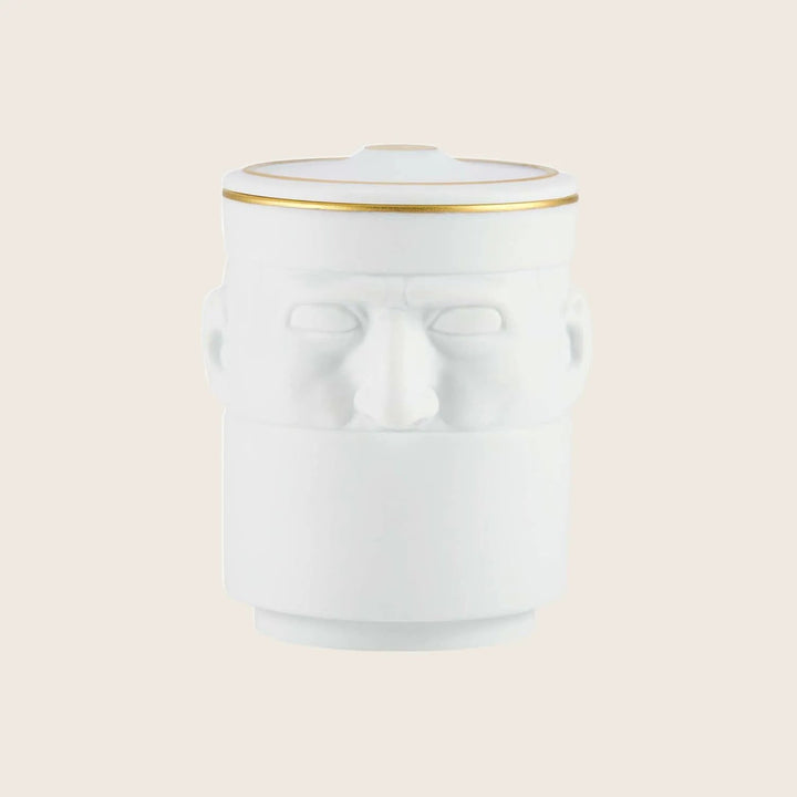 White ceramic jar with embossed human face design and gold trim.