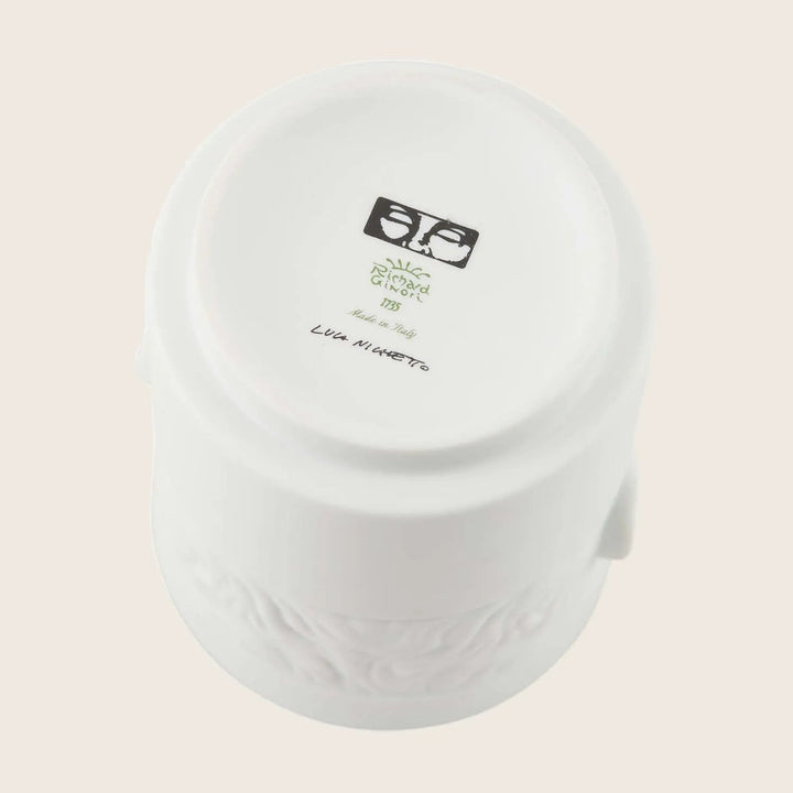 Underside of white ceramic item with branding and markings details.
