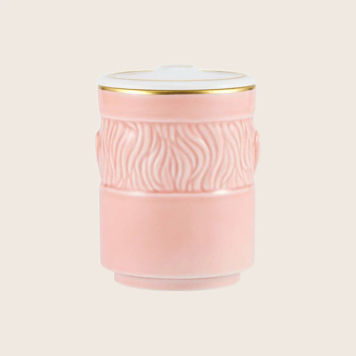 Decorative pink ceramic container with textured wave pattern and gold accent