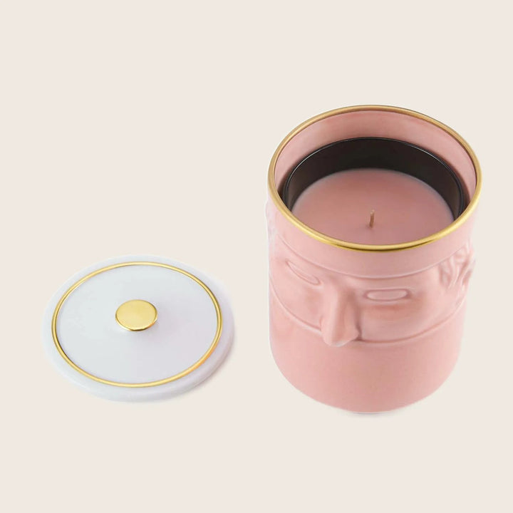 Decorative pink candle in elegant container with gold accents, lid.