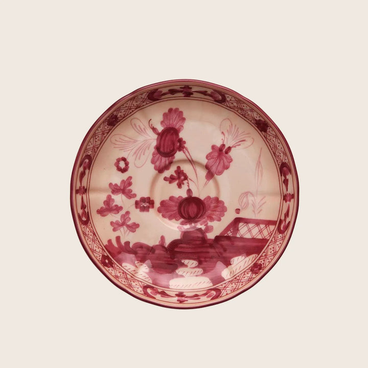Ornate round plate with red floral design on cream base