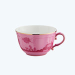 Porcelain pink teacup with floral design and elegant gold rim.