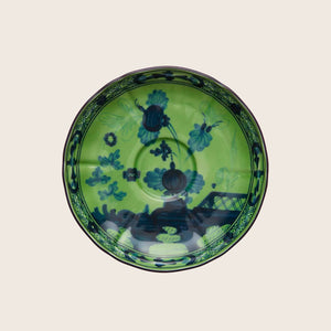 Vibrant decorative plate with blue floral pattern on green background.
