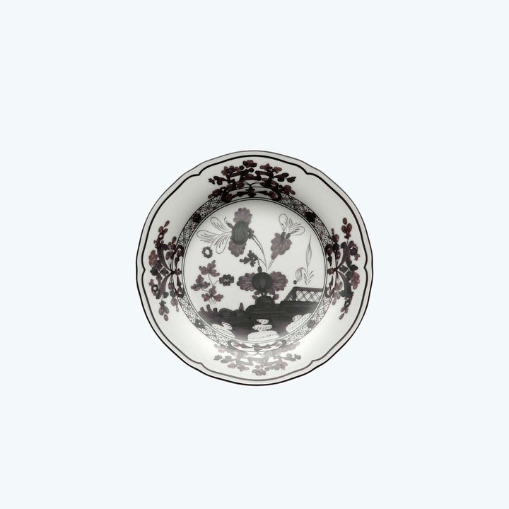 Intricately designed circular plate in dark tones with floral motifs.