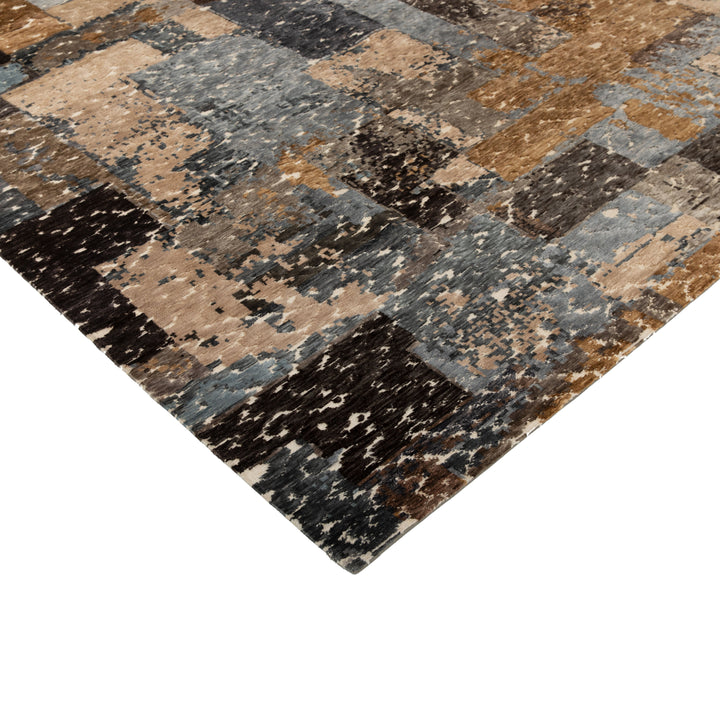 Abstract patchwork rug in shades of blue, brown, beige, black.