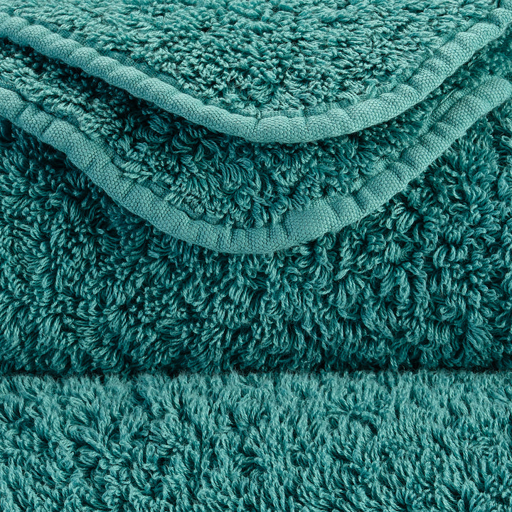 Close-up view of teal terry cloth towels, showcasing looped pile.