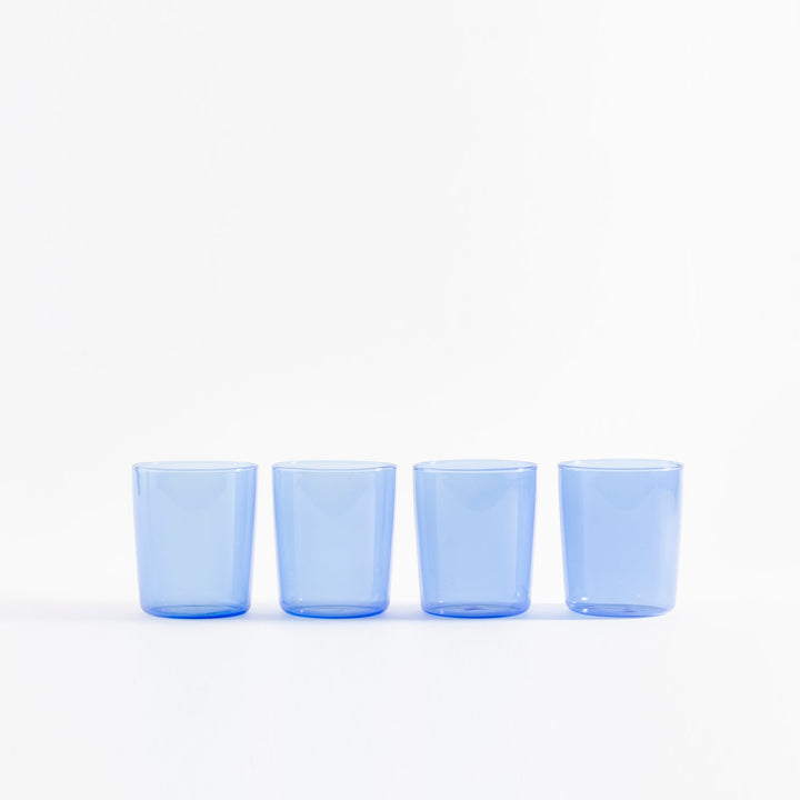 Four identical blue glass cups in a horizontal line arrangement.