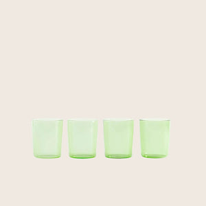 Four green translucent shot glasses arranged in a straight line. - hover