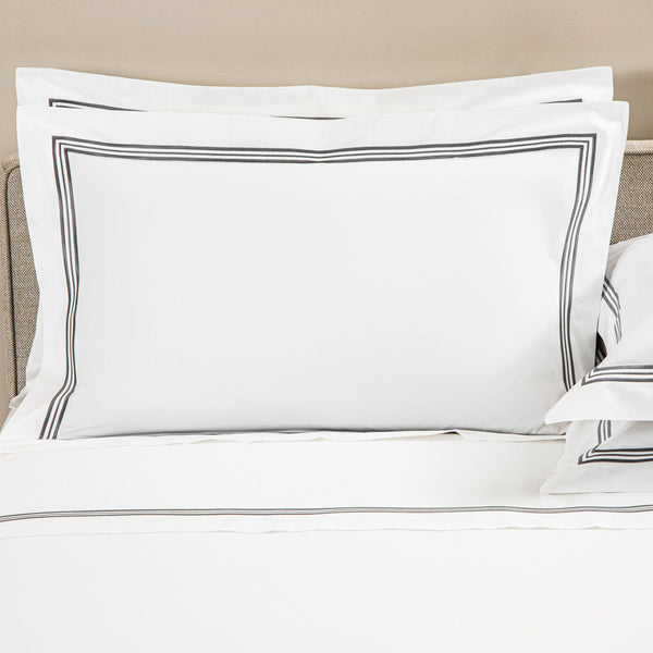 Elegant bed with crisp white bedding and subtle striped accents.