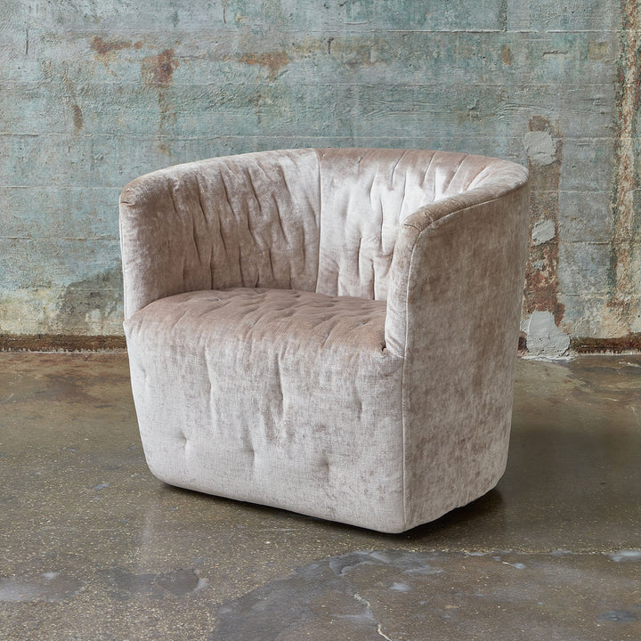 Vintage plush armchair against weathered wall in urban industrial setting.