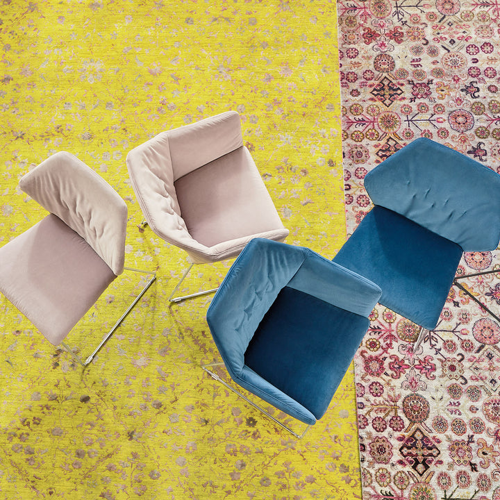 Three chairs on different rugs showcase diverse interior design styles.