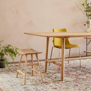 Simple and modern wooden stool with ergonomic curved seat. - hover