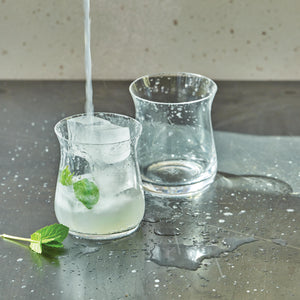 Modern clear glass pitcher with yellow tint, minimalistic setting. - hover