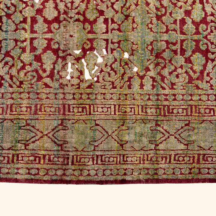 Intricate antique rug with floral motif and geometric border design.