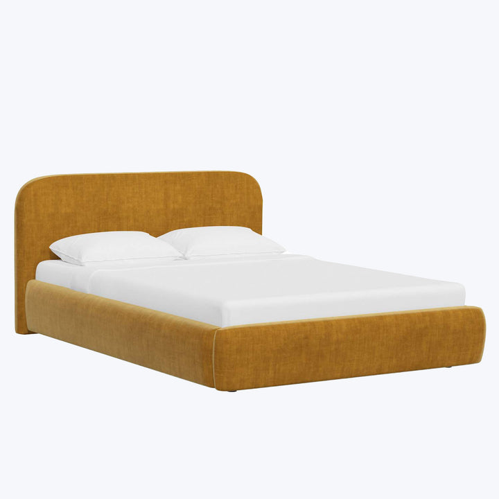 Modern mustard upholstered bed with white bedding in contemporary setting.