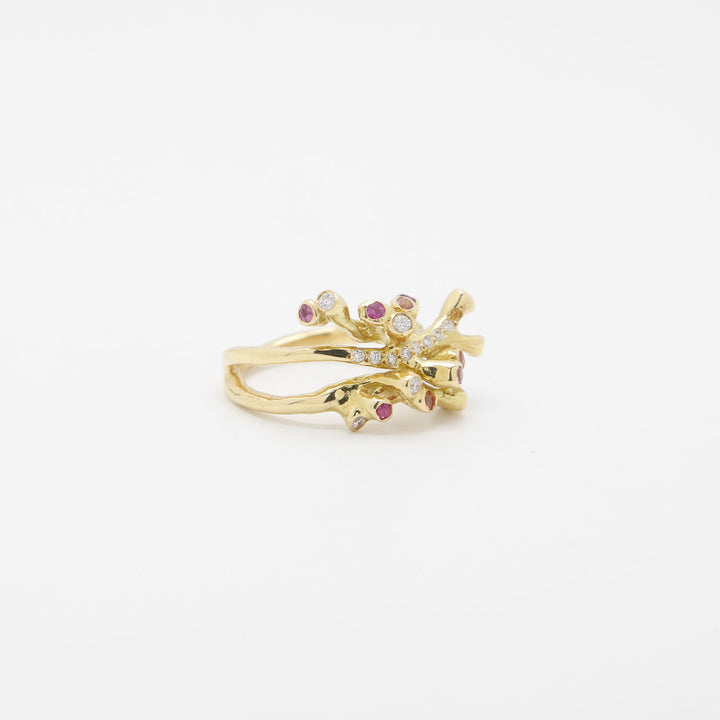 Elegant gold ring with floral design and colorful gemstones.