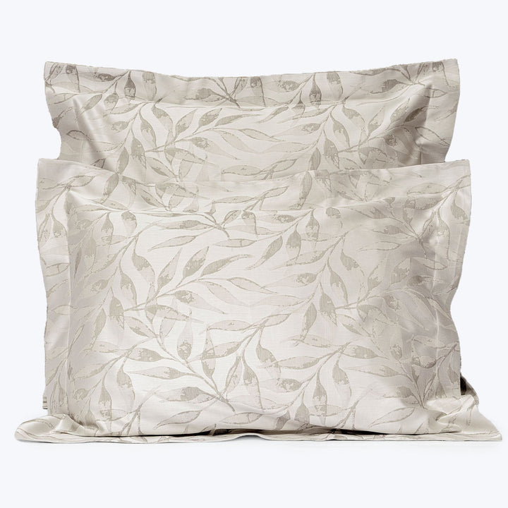 Neutral beige pillowcases with botanical design add elegance to bedding.