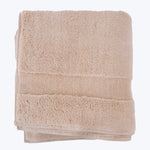 Neatly folded beige bath towel with decorative ribbed band detail.