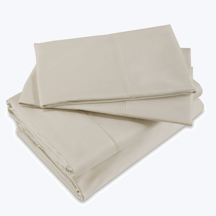 Neatly folded beige bed sheets with quality stitching detail.