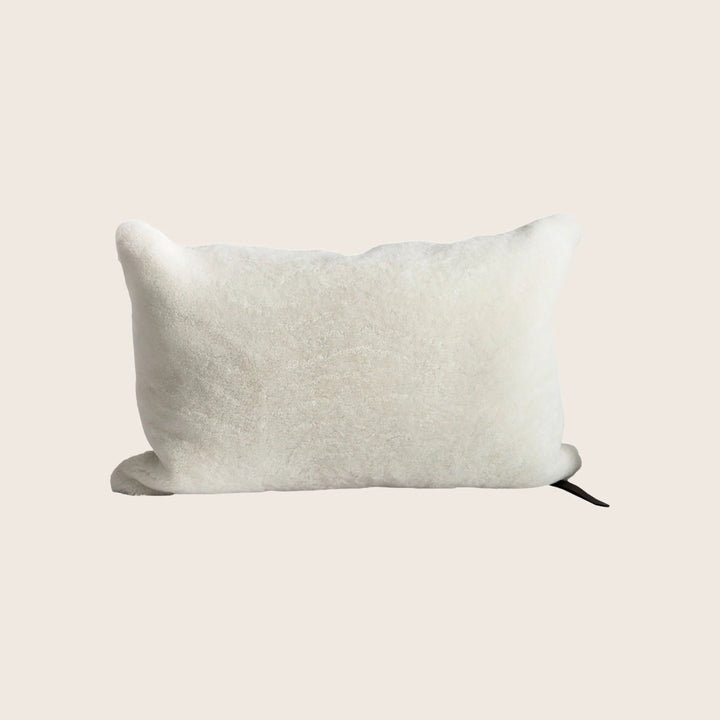 Soft, fluffy rectangular pillow with raised edges and tag label.
