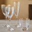 Elegant glassware with gold rims on wooden tabletop display luxury.