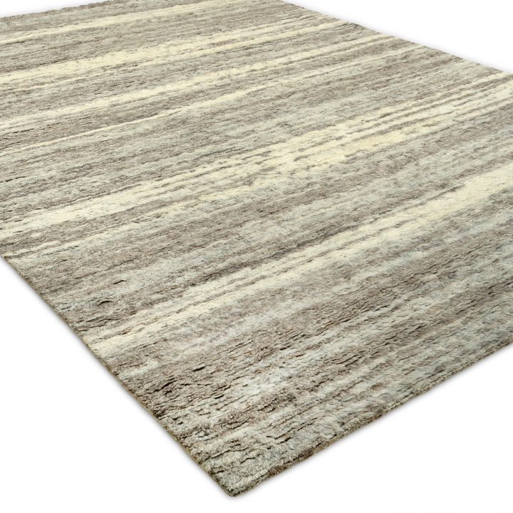 Rectangular area rug with gradient pattern in beige, cream, gray.