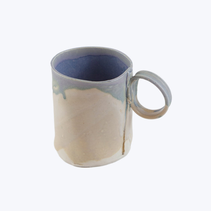 Handcrafted ceramic mug with beige to blue gradient and drippy glaze.