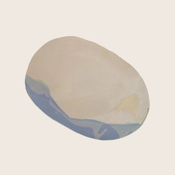 Elliptical object with marbled cream, beige, blue and green pattern.