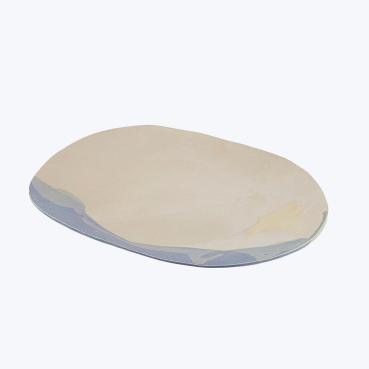 Handcrafted ceramic plate with pastel tones in irregular oval shape.