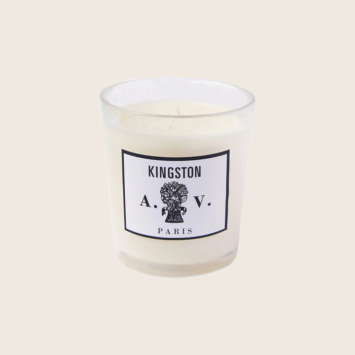Single unlit candle in glass jar with Kingston A.V. Paris label