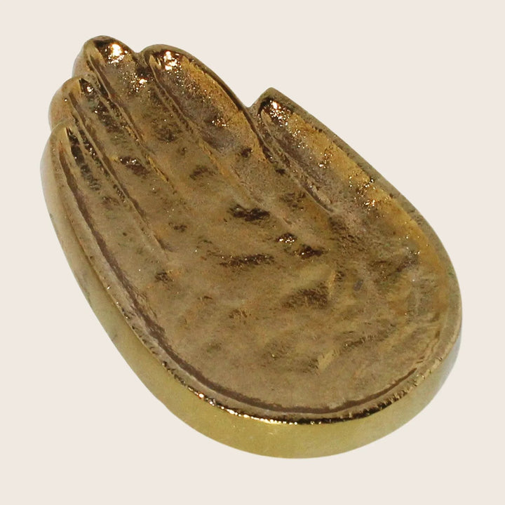 Gold seashell sculpture with intricate details on white background.