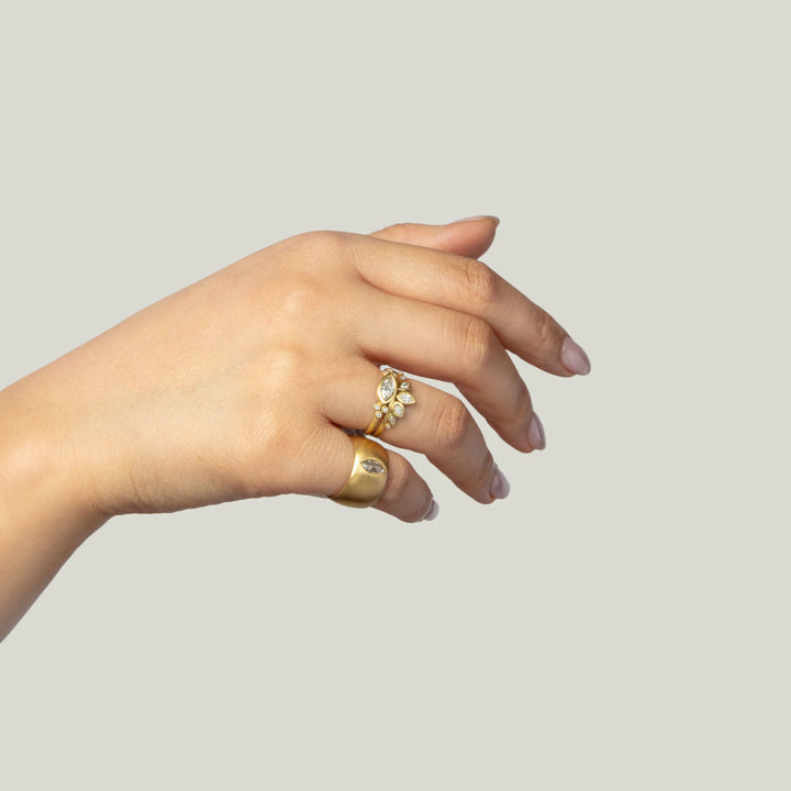 Elegantly adorned hand with gold rings and gemstone embellishments.