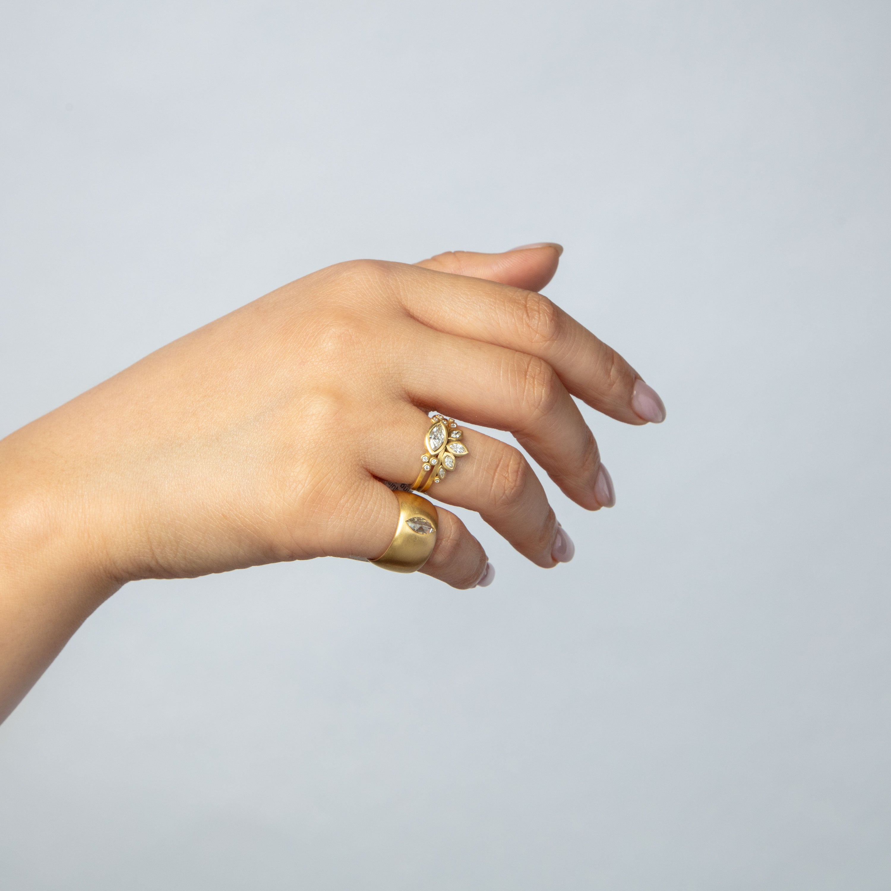 Elegantly adorned hand with gold rings and gemstone embellishments.