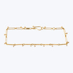 Delicate gold bracelet with intricate design featuring gemstone embellishments.