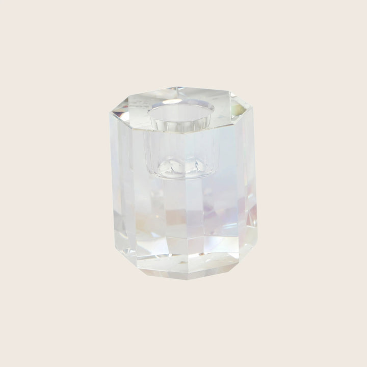 Faceted hexagonal glass object with prismatic reflections on white background.