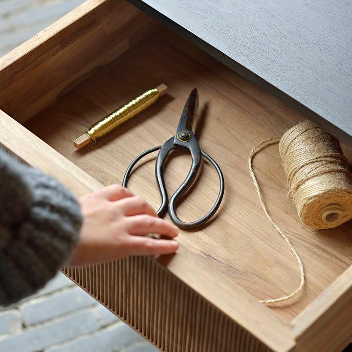 Craft drawer with scissors, thread, and twine in organized space.