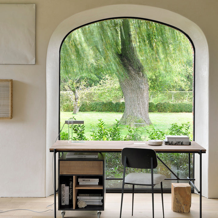 Modern minimalist interior with large arch window overlooking tranquil garden.