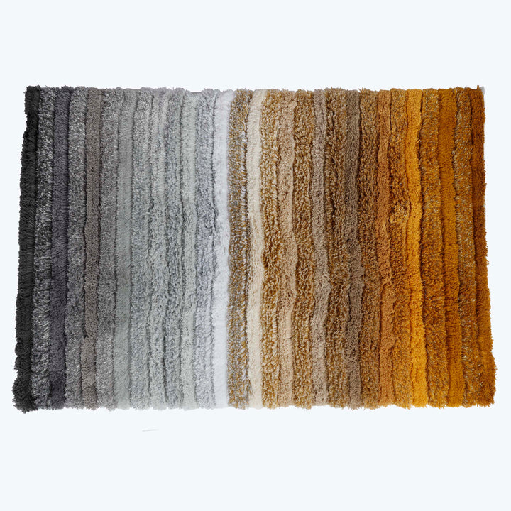 Gradient of color tones in shaggy rugs from grayscale to warm.