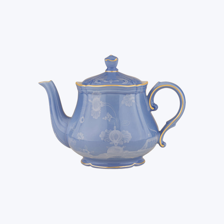Blue ceramic teapot with floral patterns and glossy finish.