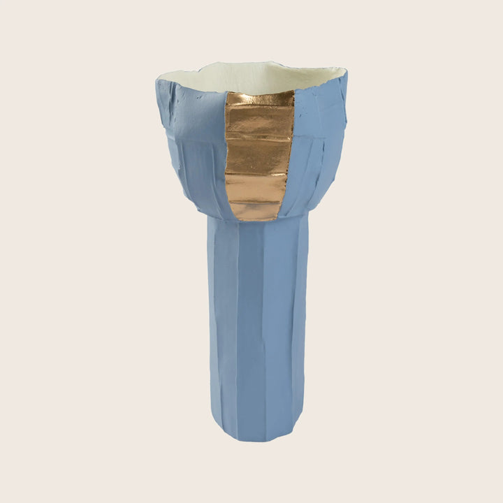 Geometric blue pedestal with cream top and metallic gold accents.