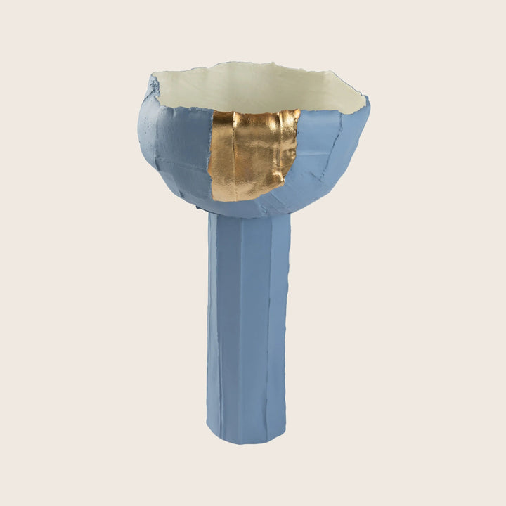 Abstract blue sculptural object with gold leaf detail on top bowl.