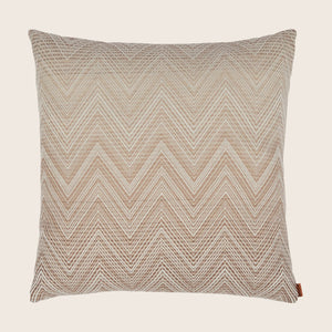 Neutral chevron patterned pillow with tag on white background.